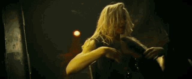 a woman in a red dress is holding a man 's arm in a dark room .