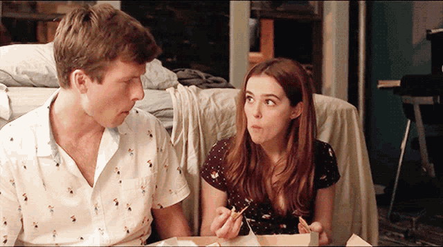 a man and a woman sitting at a table eating