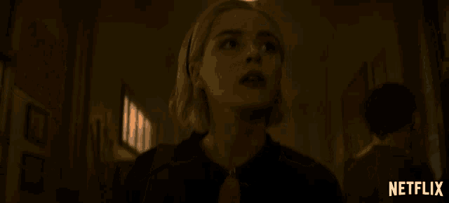 a woman in a dark hallway with a netflix logo in the corner