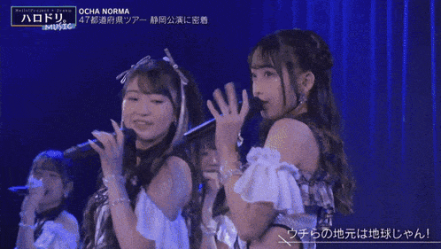 two girls singing into microphones with ocha norma written on the bottom