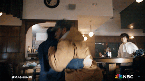 a man is hugging another man in a room with nbc written on the bottom