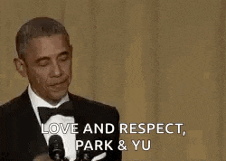barack obama is wearing a tuxedo and bow tie and waving at the crowd .
