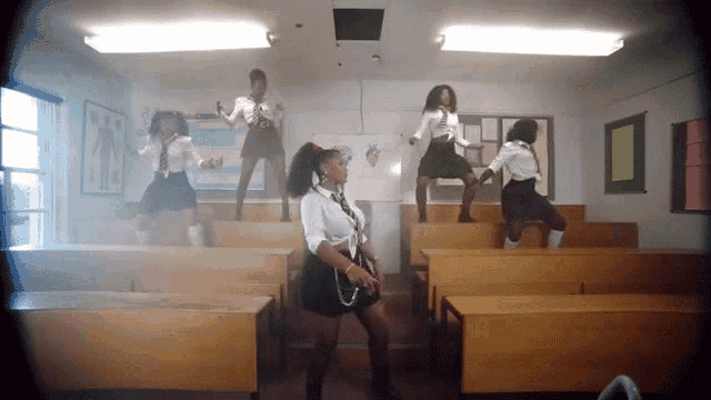 a group of women are dancing in a classroom