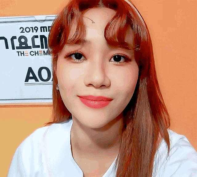 a woman with red hair stands in front of a sign that says the chem