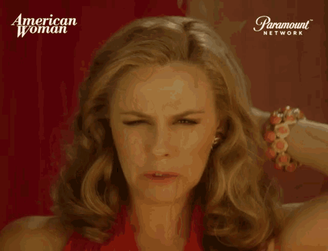 a woman in a red dress is holding her hair in front of a paramount network logo