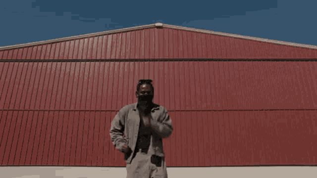 a man standing in front of a large red building