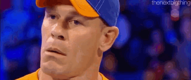 a close up of a man wearing a hat and a yellow shirt .