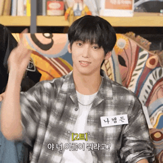 a young man wearing a plaid shirt has a name tag that says 2