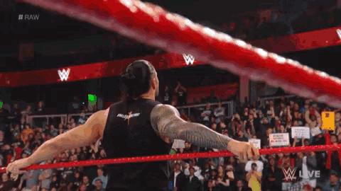 a man in a wrestling ring with a sign that says raw on it