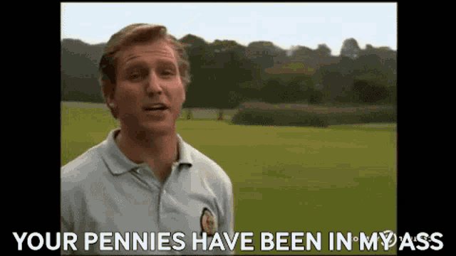 a man in a polo shirt is standing in a field and talking to someone .