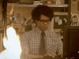 a man wearing glasses is typing on a computer keyboard