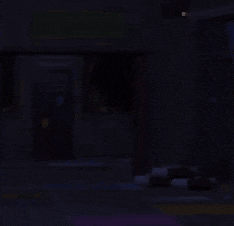 a dark room with a door that is open and a couch in the foreground .
