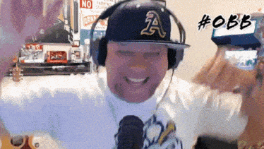 a man wearing headphones and a hat with a letter a on it
