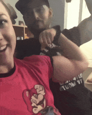 a man and a woman are flexing their muscles and the woman is wearing a shirt that says " suomi "