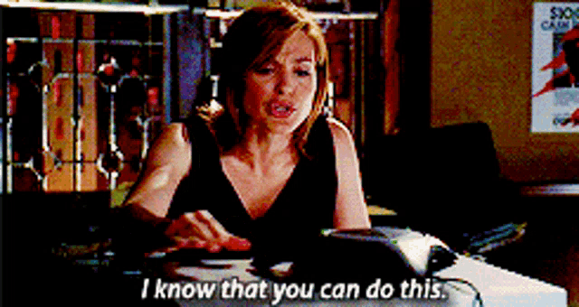 a woman in a black dress is sitting at a desk and says i know that you can do this