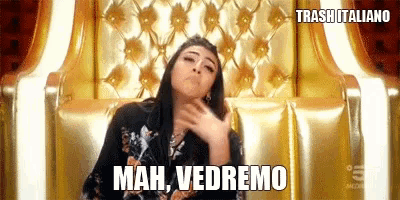 a woman is sitting on a gold couch and making a funny face while saying mah vedremo .