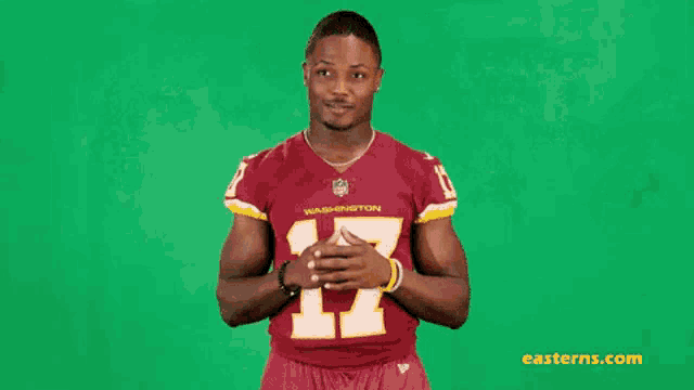 a man wearing a washington redskins jersey is smiling