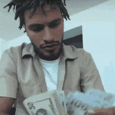 a man with dreadlocks is holding a bunch of money