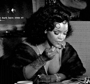 a black and white photo of a woman sitting at a table eating food with a spoon .