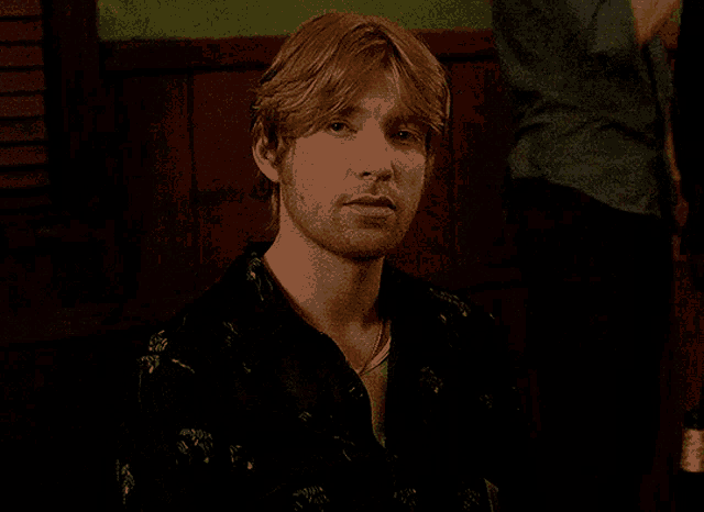 a man with blonde hair and a beard wearing a black shirt