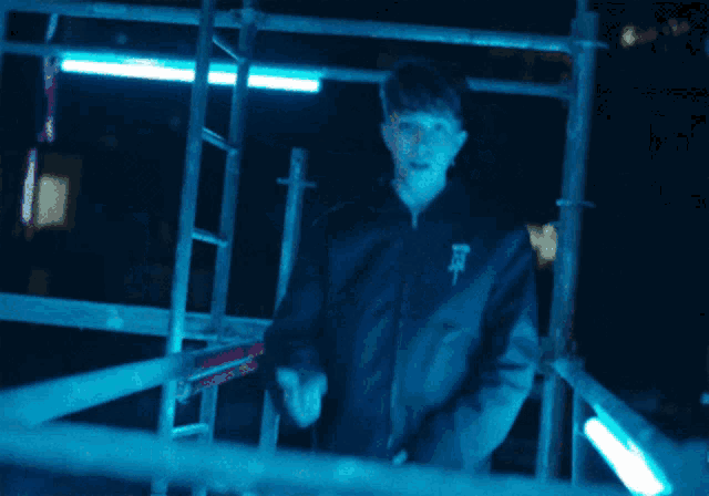 a man wearing a black jacket with the letter r on it