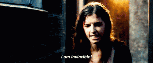 a woman in a dark room says i am invincible .