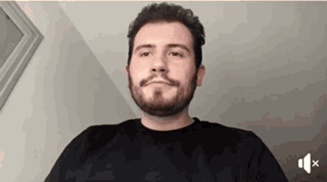 a man with a beard is wearing a black shirt