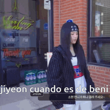 a woman standing in front of a store that says jiyeon