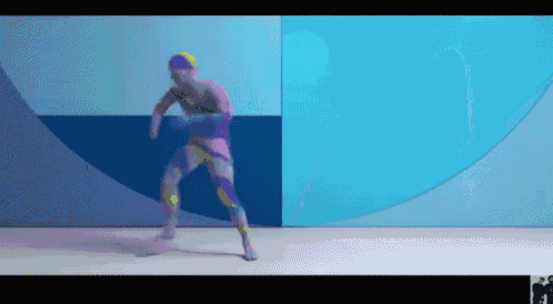 a man in a colorful bodysuit is dancing in front of a blue wall .