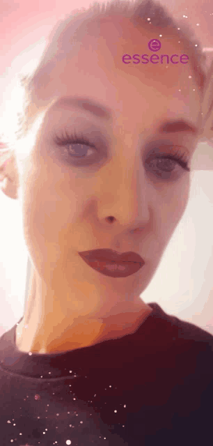 a close up of a woman 's face with a purple essence logo on her forehead