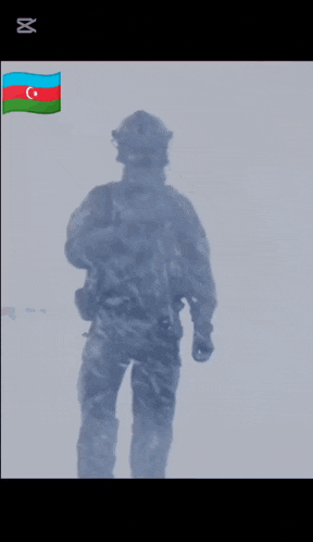 a soldier is standing in front of a flag and a sign that says " ro "