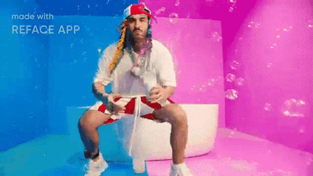 a man is sitting on a toilet in a pink room with bubbles .