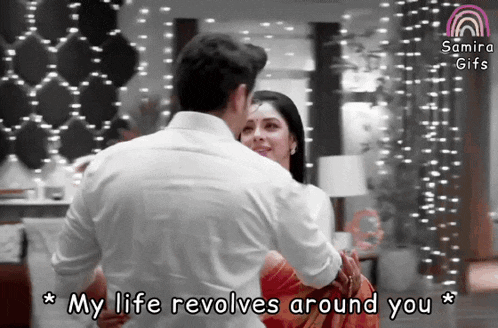 a man is holding a woman in his arms with the caption my life revolves around you