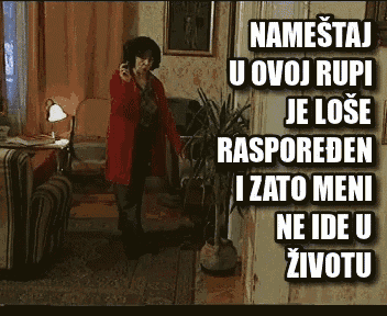 a woman in a red coat talking on a cell phone in a living room