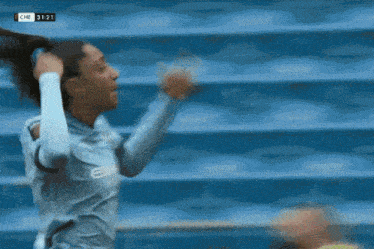 a woman running on a soccer field in front of a crowd that says revolution