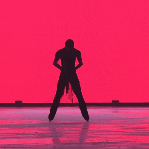 a silhouette of a figure skater against a pink background