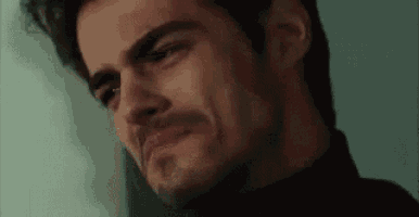 a close up of a man 's face with a tear running down his cheek .