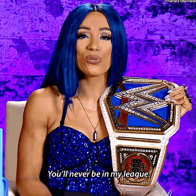 a woman with blue hair is holding a wrestling championship belt and saying you 'll never be in my league