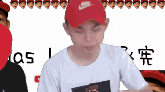 a man wearing a red nike hat stands in front of a white background
