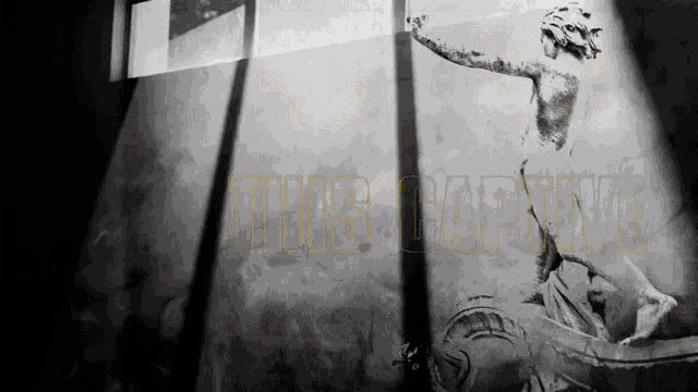 a black and white photo of a statue with the words " this captive " in yellow