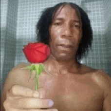 a man is holding a red rose in his hand .