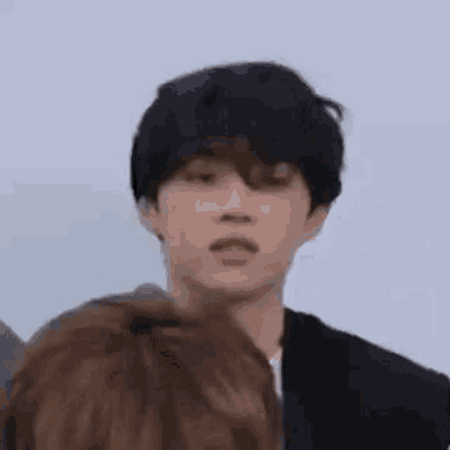 a close up of a person making a funny face while standing next to another person .