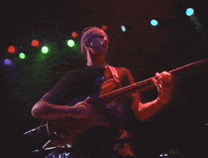 a man in a black shirt is playing a guitar