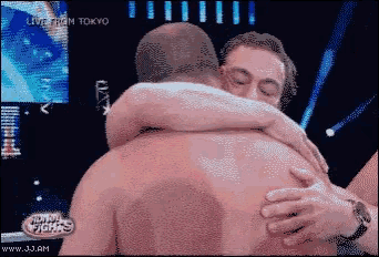 a pixelated image of two men hugging with the words live from tokyo