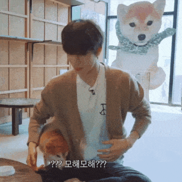 a man in a brown cardigan is holding a small dog in his lap