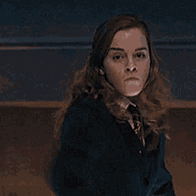 a woman in a school uniform is holding a wand with a light coming out of it .