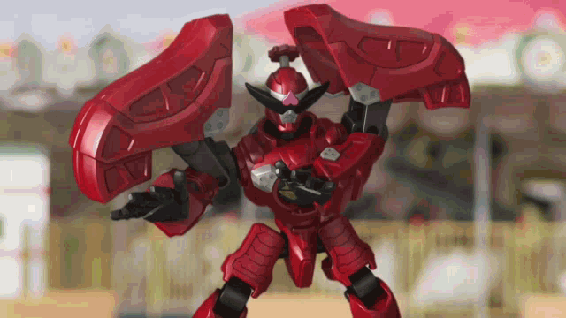a red robot with black arms and a pink face
