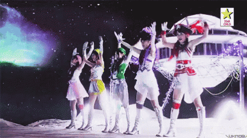 a group of women are dancing in front of a sign that says star fm3