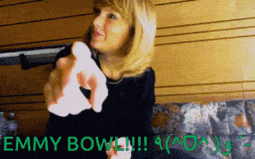 a woman is holding a white object and the words emmy bowl are above her