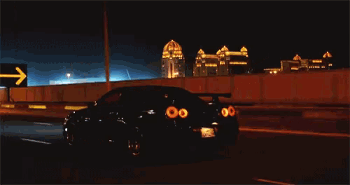 a car is driving down a highway at night with a sign in the background that says ' ksa '
